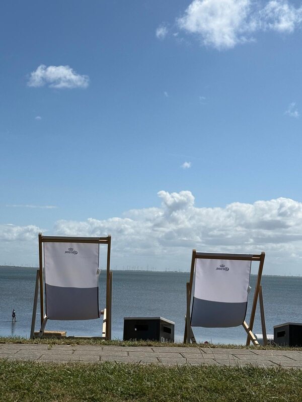 Zwei große Liegestühle am Deich mit Blick auf die Nordsee